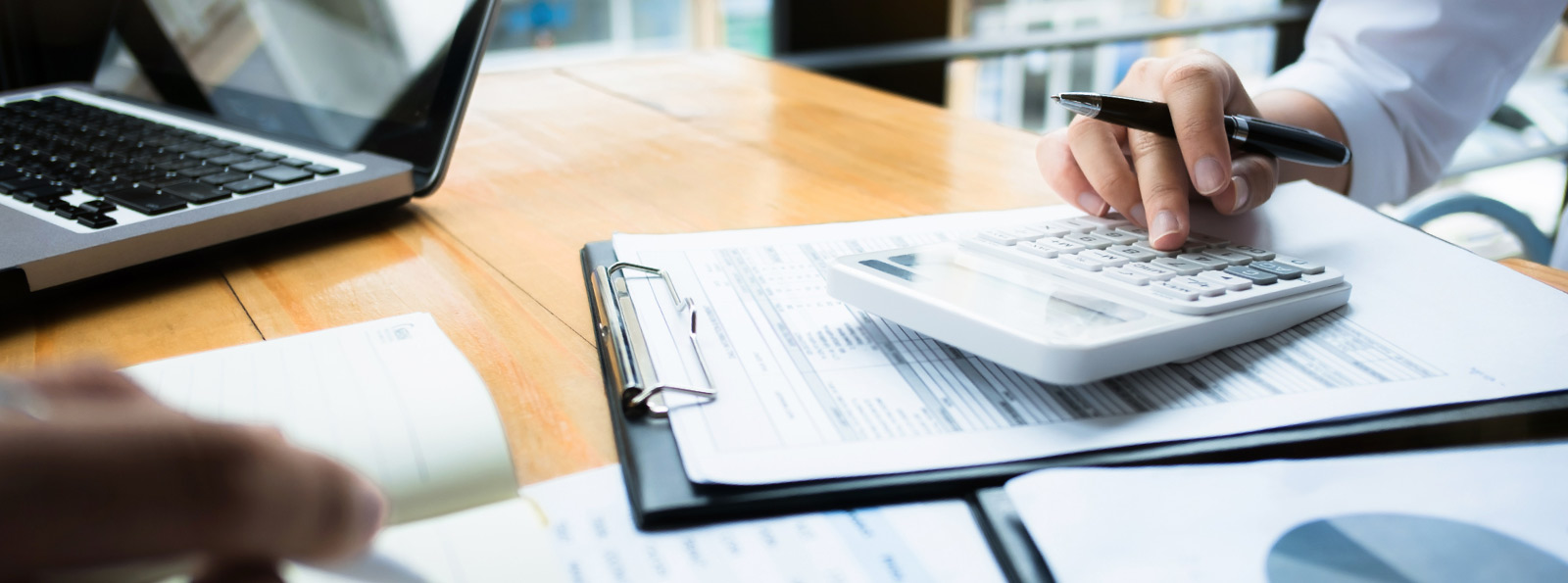 Man using calculator at desk with documents