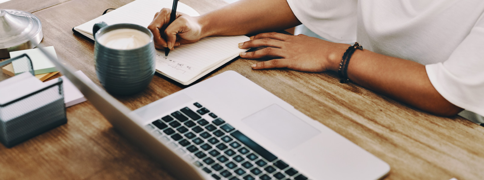 Woman with notebook at laptop