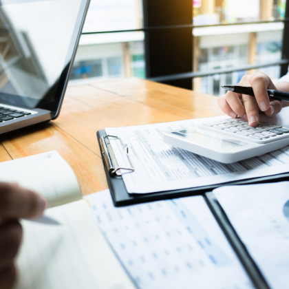 Man using calculator at desk with documents